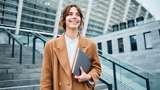 Giovane professionista sorridente con laptop, simbolo di crescita HR e consulenza del lavoro efficiente.