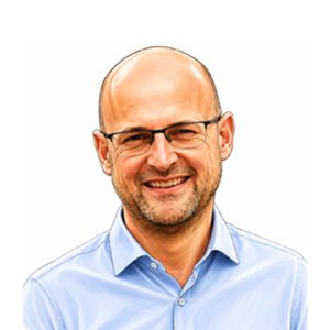 Porträt von Lorenzo Andreoli, Arbeitsberater bei Studio Sette, lächelnd und mit Brille, in einem hellblauen Hemd.